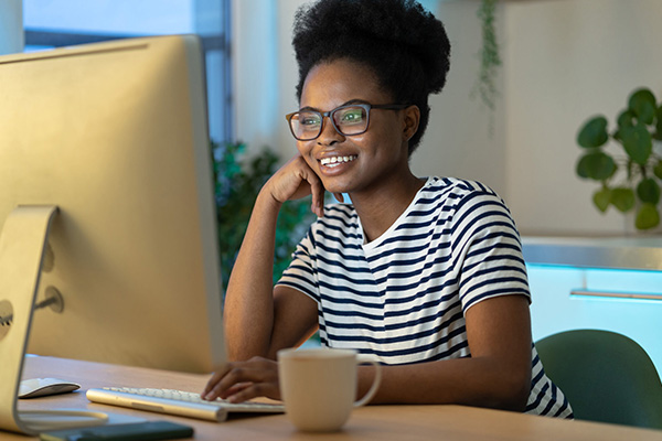 A woman smiling while using her computer