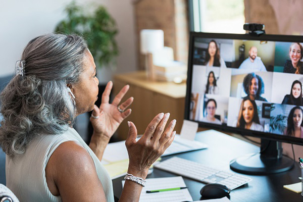 A woman at a computer attending a virtual meeting