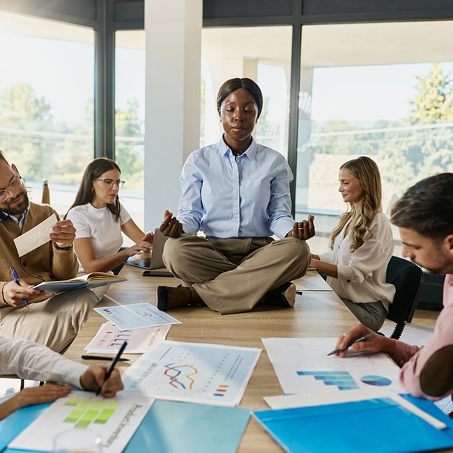 Woman sitting on conference desk practicing Yoga