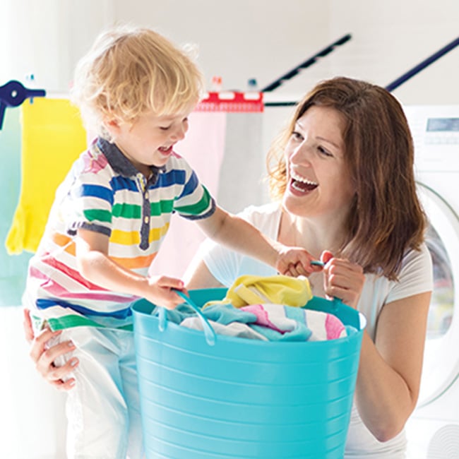 A child helping his mother hold a laundry basket